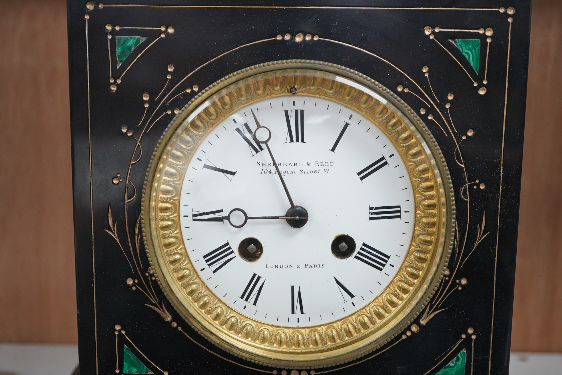 A late 19th century, French black marble eight day mantel clock, inset with malachite, retailed by Shepheard & Rees, with pendulum, no key, 26cm high. Condition - fair, minor chipping, untested